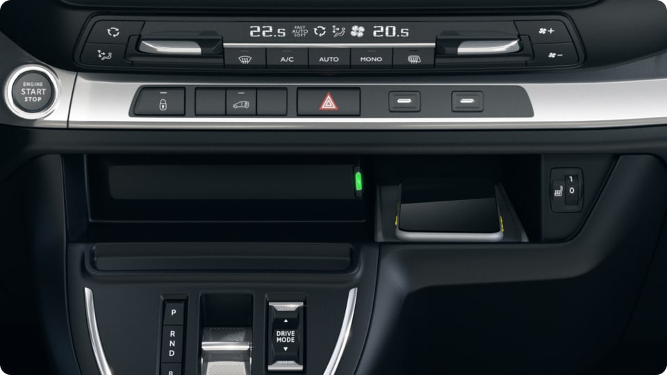Vivaro’s center console showing climate controls and a smartphone charging